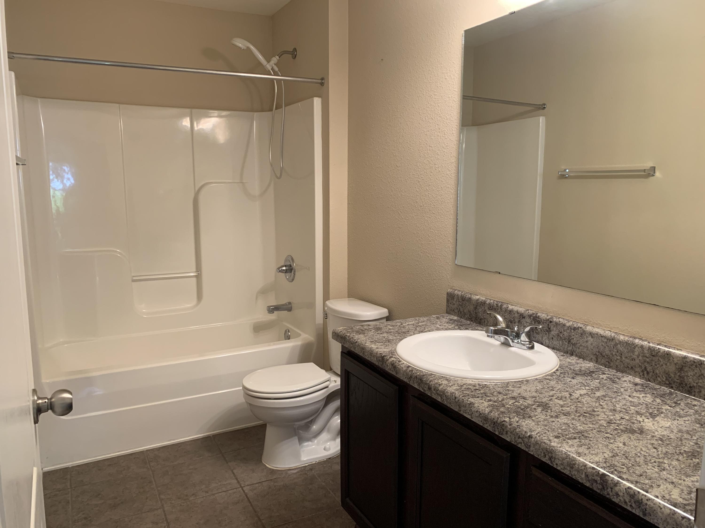 4587 Hermosa Road Crestview, FL 32539 - Photo 17 of 21 a bathroom with a granite countertop sink toilet and shower