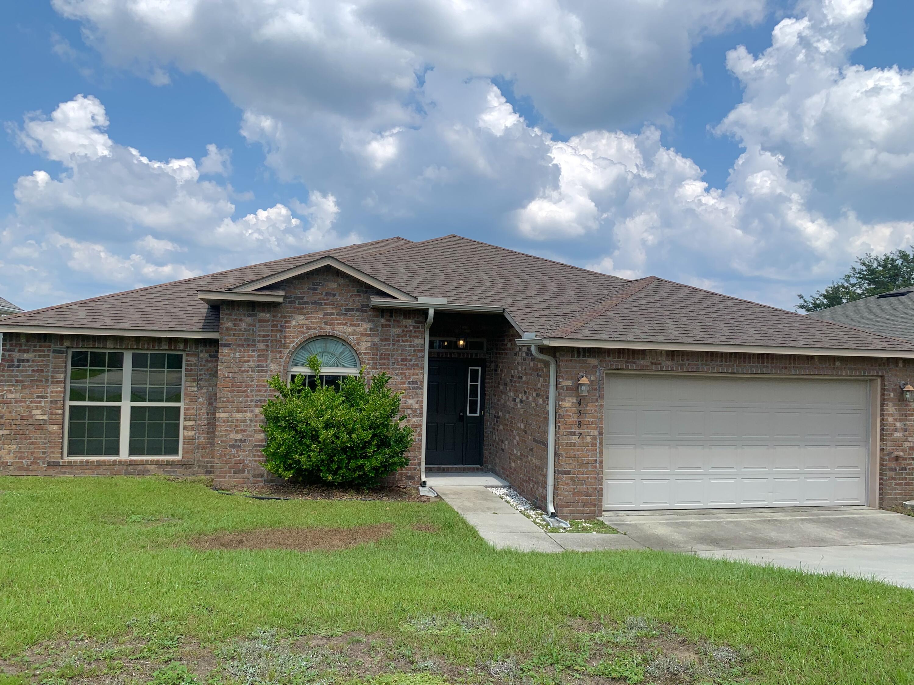 4587 Hermosa Road Crestview, FL 32539 - Photo 2 of 21 a front view of a house with a yard and garage