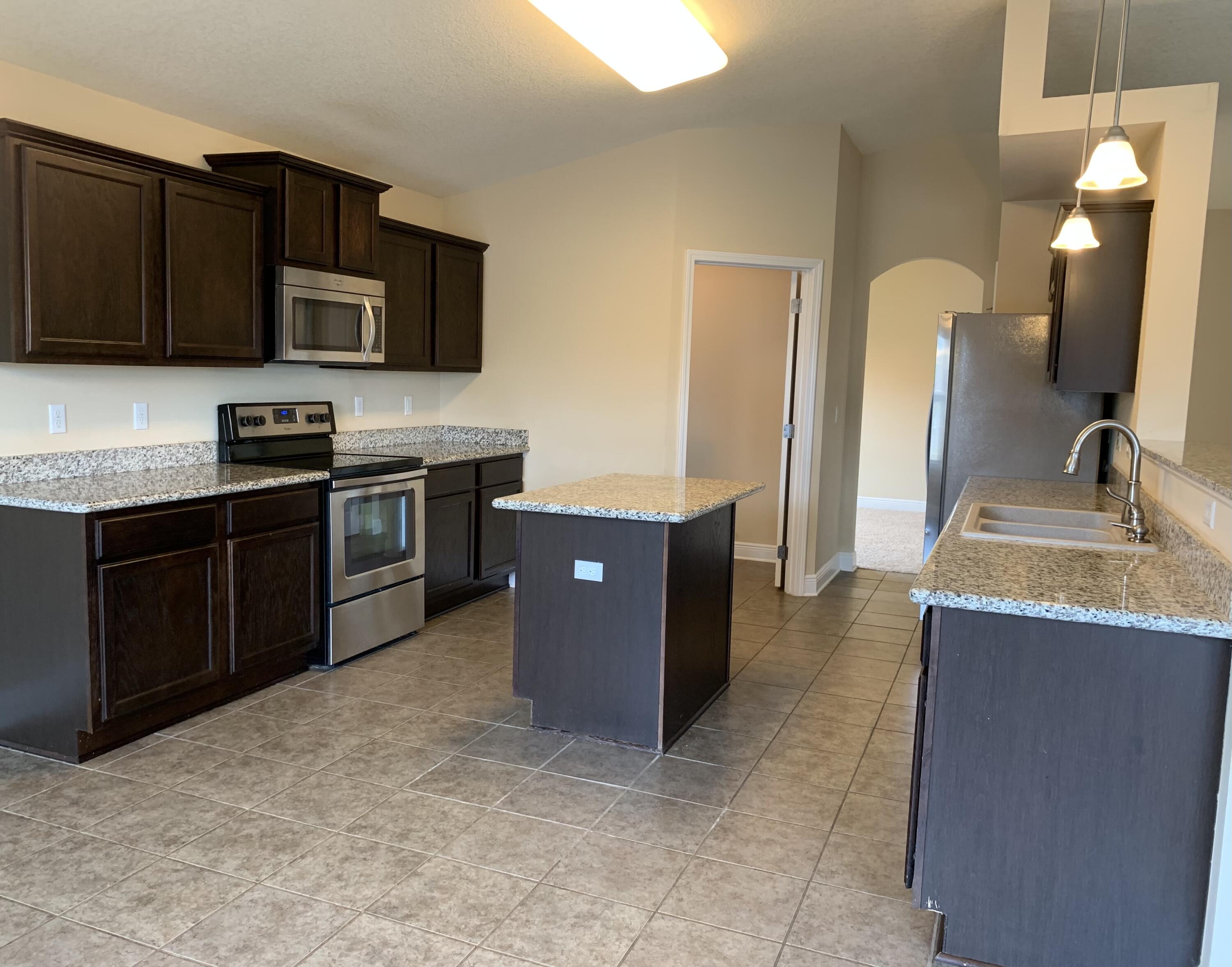 4587 Hermosa Road Crestview, FL 32539 - Photo 5 of 21 a kitchen with stainless steel appliances granite countertop a stove a sink and a microwave