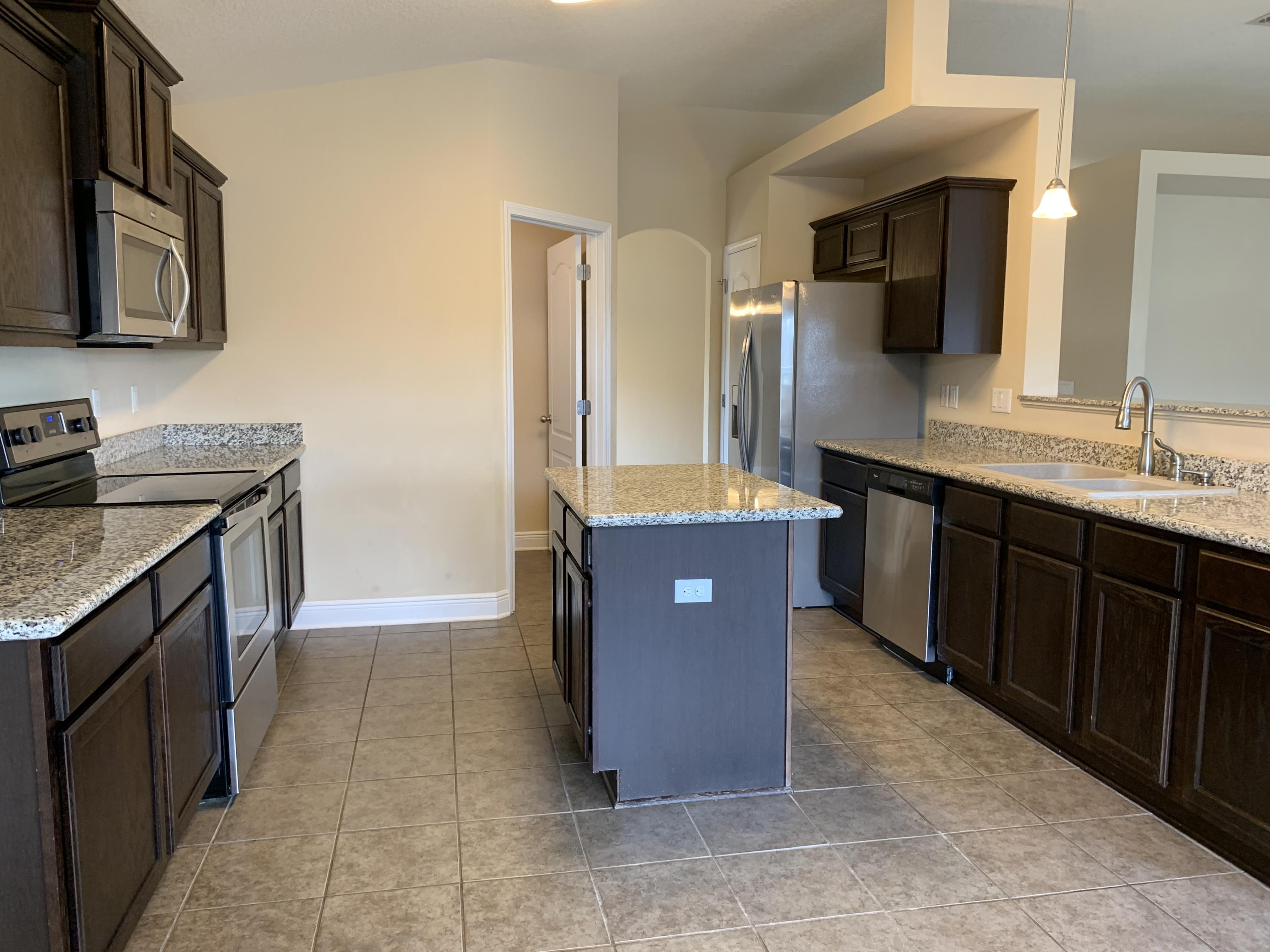 4587 Hermosa Road Crestview, FL 32539 - Photo 7 of 21 a spacious bathroom with a granite countertop sink a mirror and a bathtub