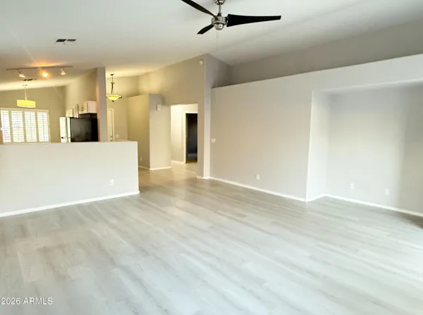 a view of a big room with wooden floor and a window