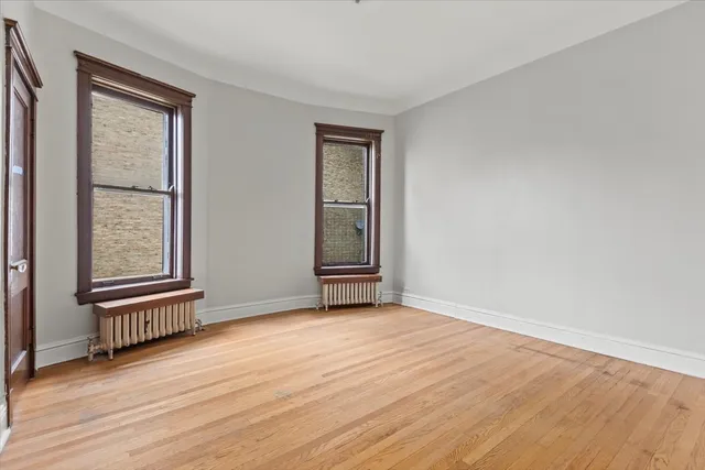 an empty room with floor to ceiling windows and fireplace