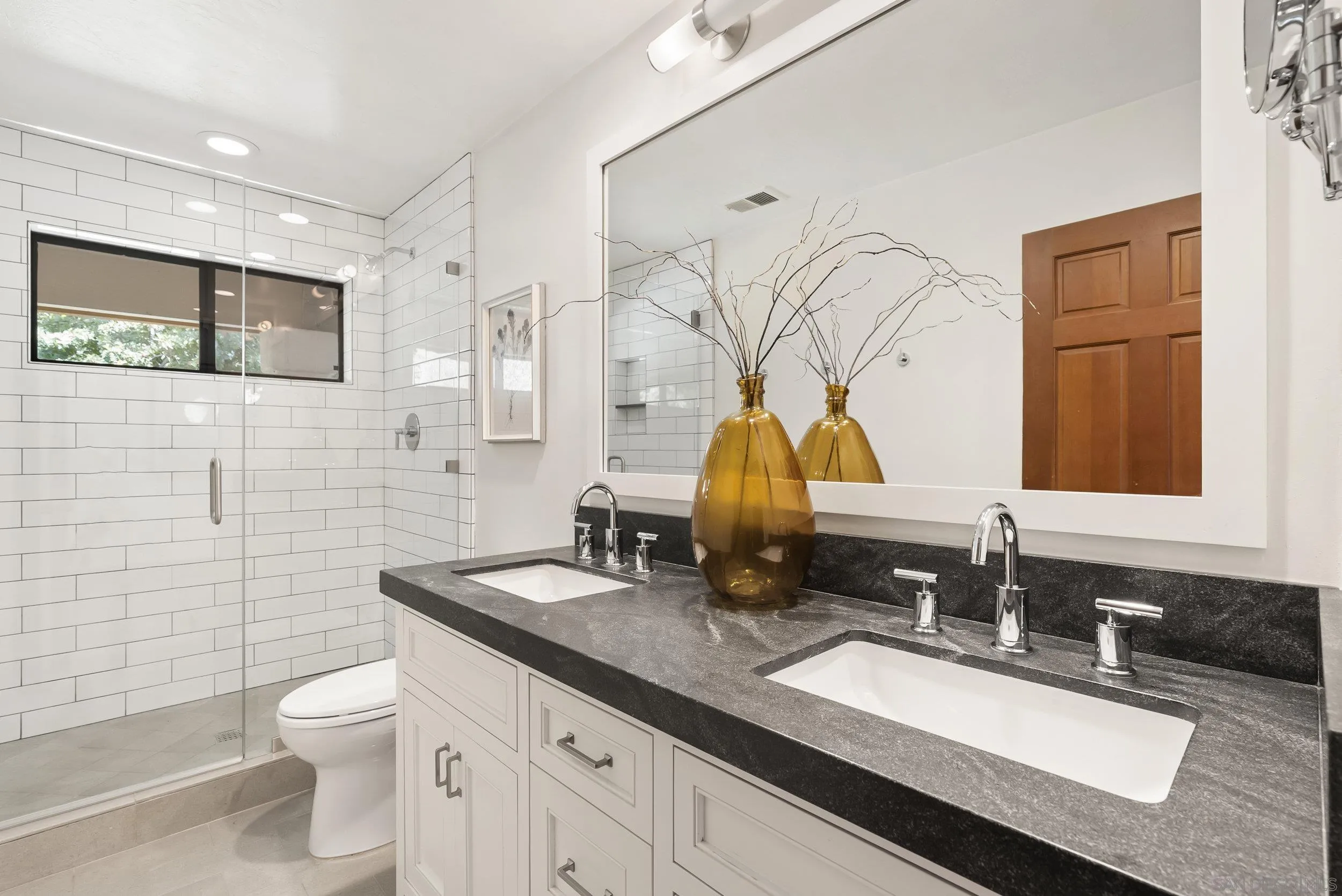 17207 El Caporal Rancho Santa Fe, CA 92067 - Photo 15 of 19 a bathroom with a granite countertop toilet sink and mirror