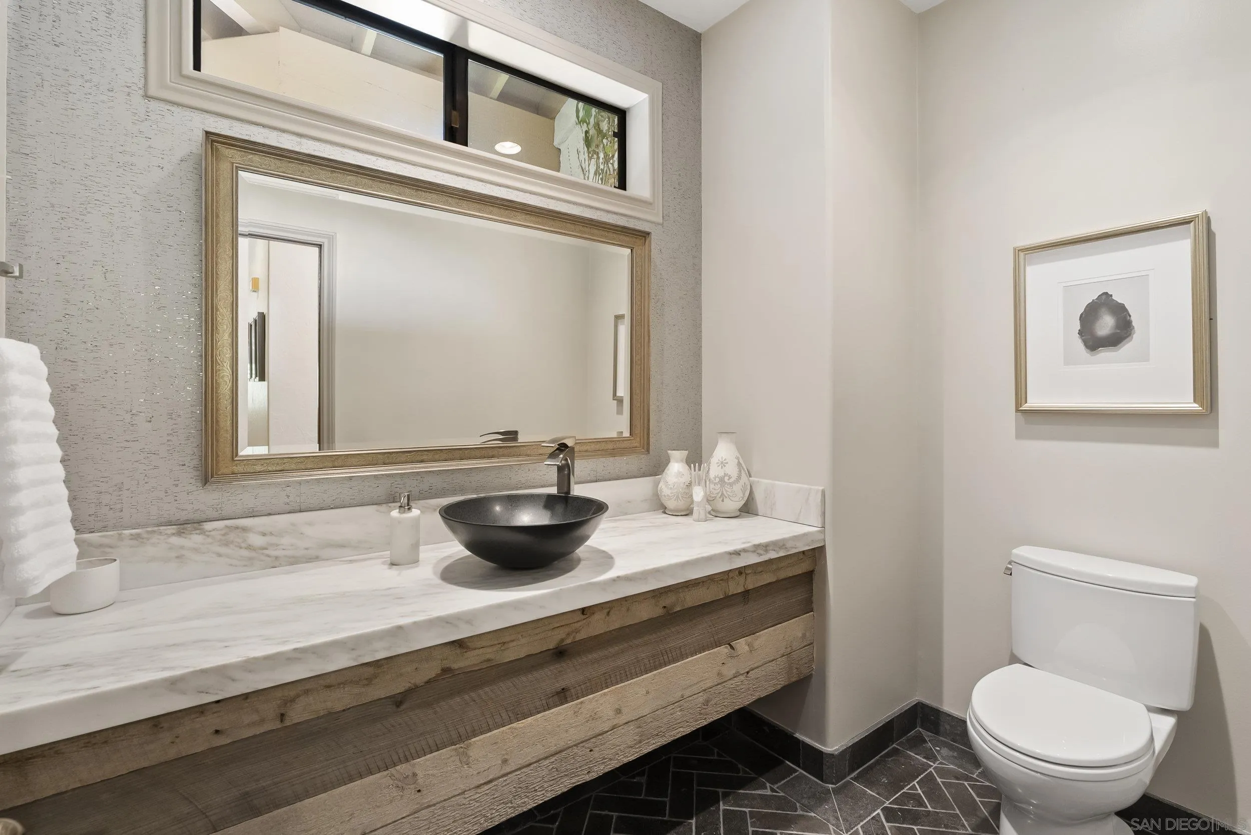 17207 El Caporal Rancho Santa Fe, CA 92067 - Photo 10 of 19 a bathroom with a toilet a sink and mirror