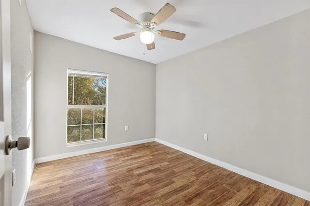wooden floor in an empty room with a window