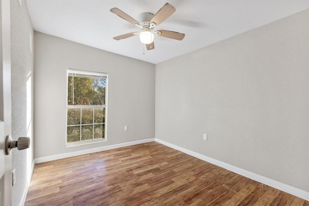 202 South Dunbar Lane Emory, TX 75440 - Photo 17 of 25 wooden floor in an empty room with a window
