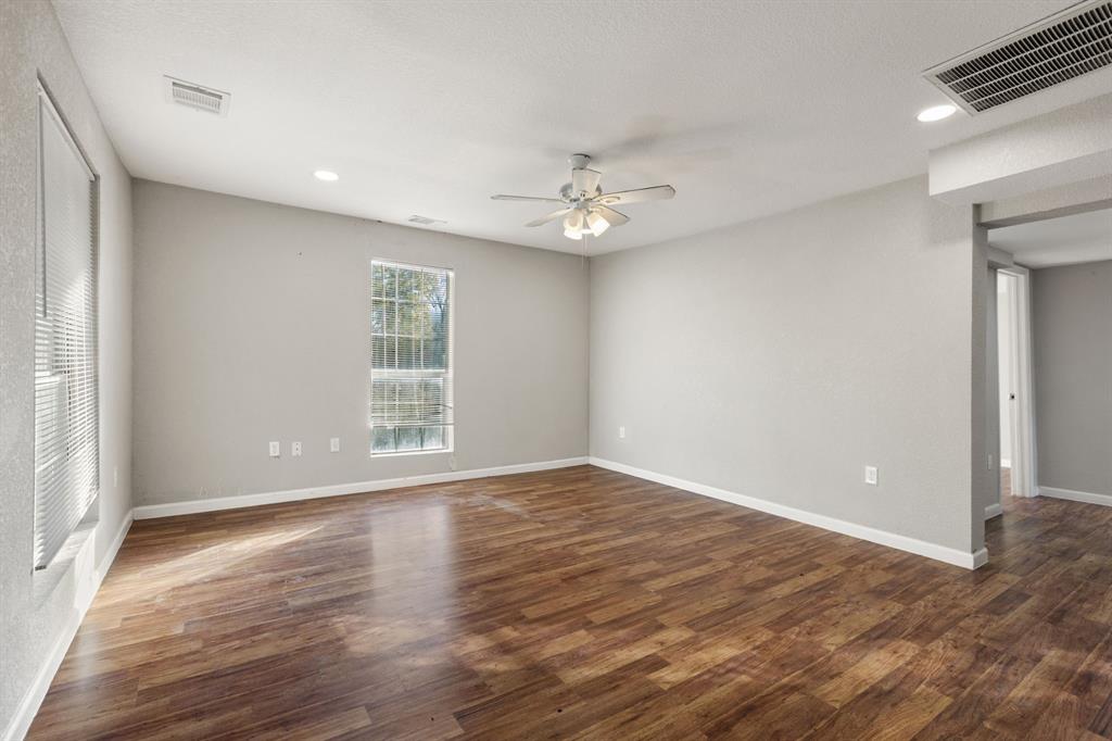 202 South Dunbar Lane Emory, TX 75440 - Photo 5 of 25 a view of an empty room with wooden floor and a window