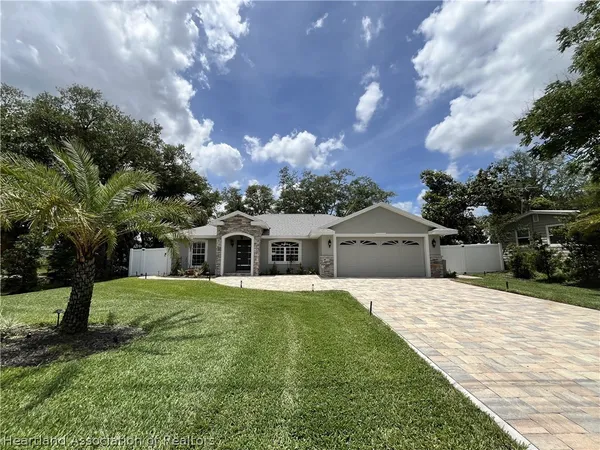a front view of a house with a yard and trees