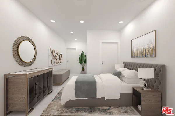 a bedroom with a large bed and a chandelier