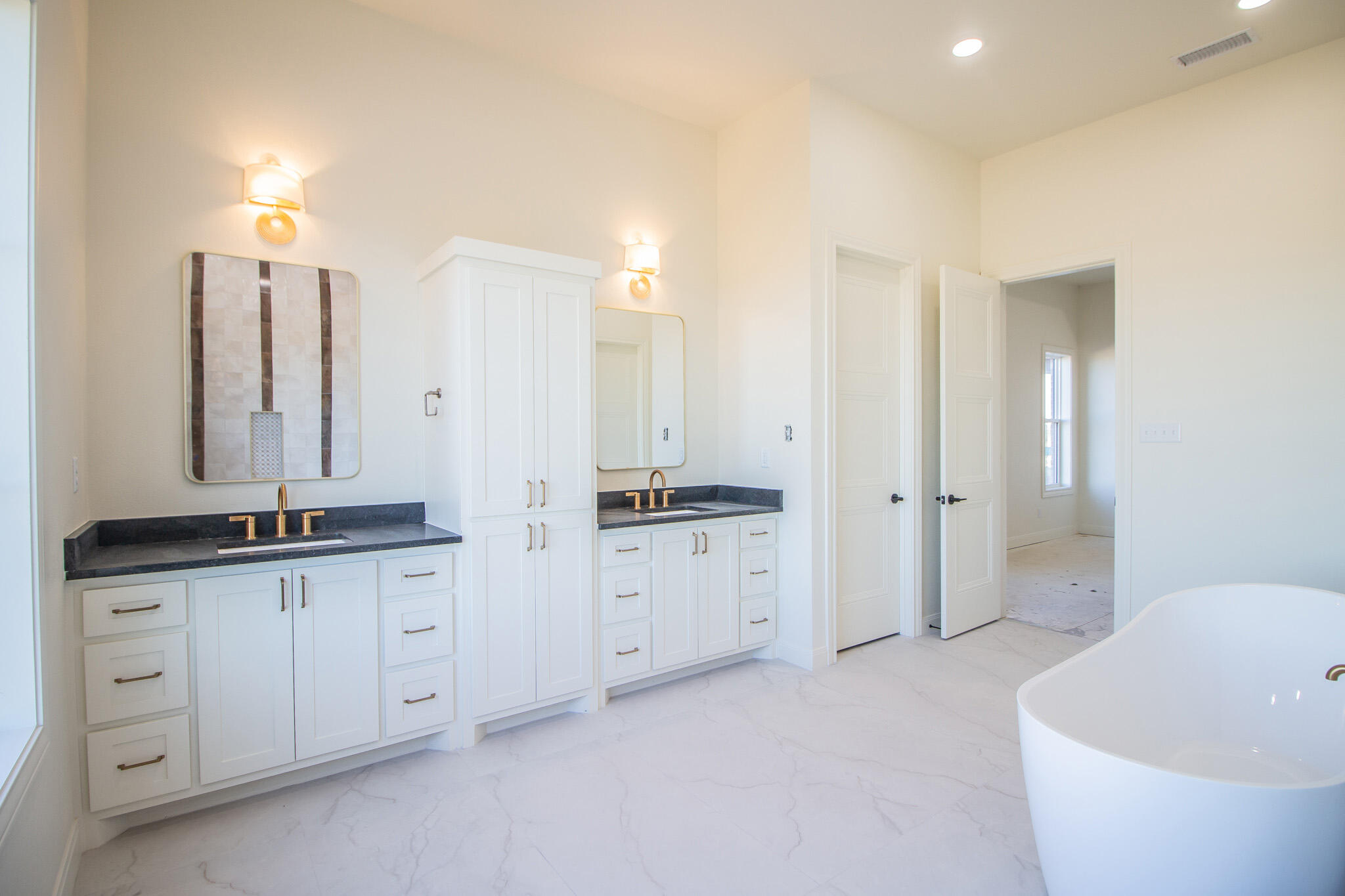 303 Juniper New Home, TX 79381 - Photo 15 of 31 a spacious bathroom with a granite countertop sink a toilet a mirror and bathtub