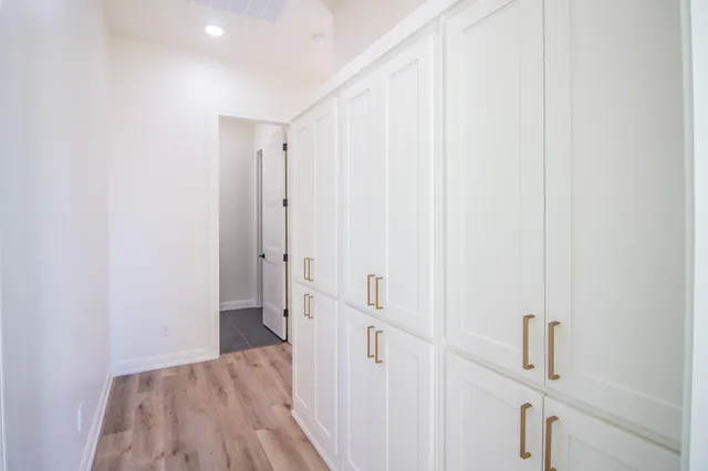 a view of a hallway with wooden floor and entryway