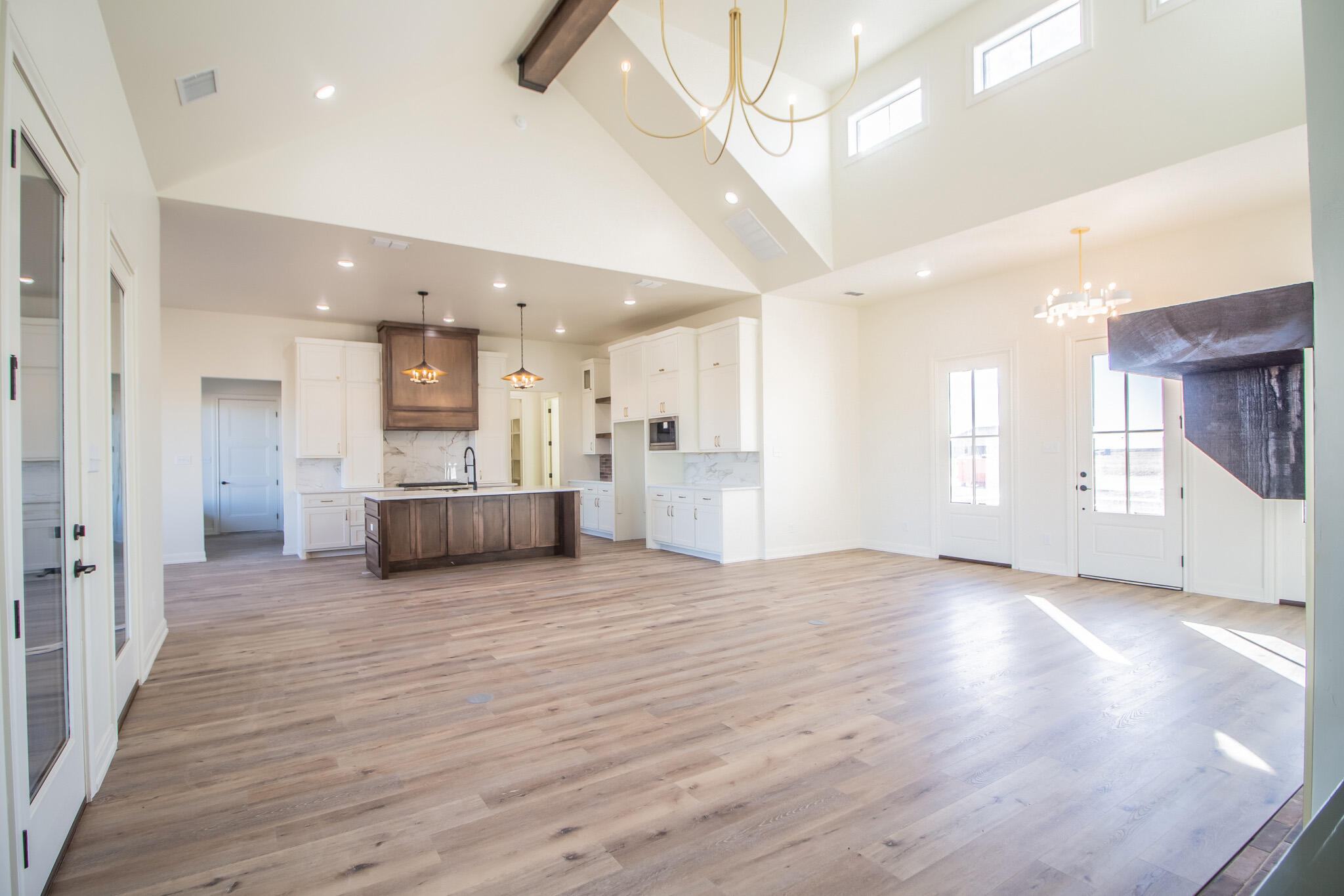 303 Juniper New Home, TX 79381 - Photo 7 of 31 a view of a big room with wooden floor and a kitchen