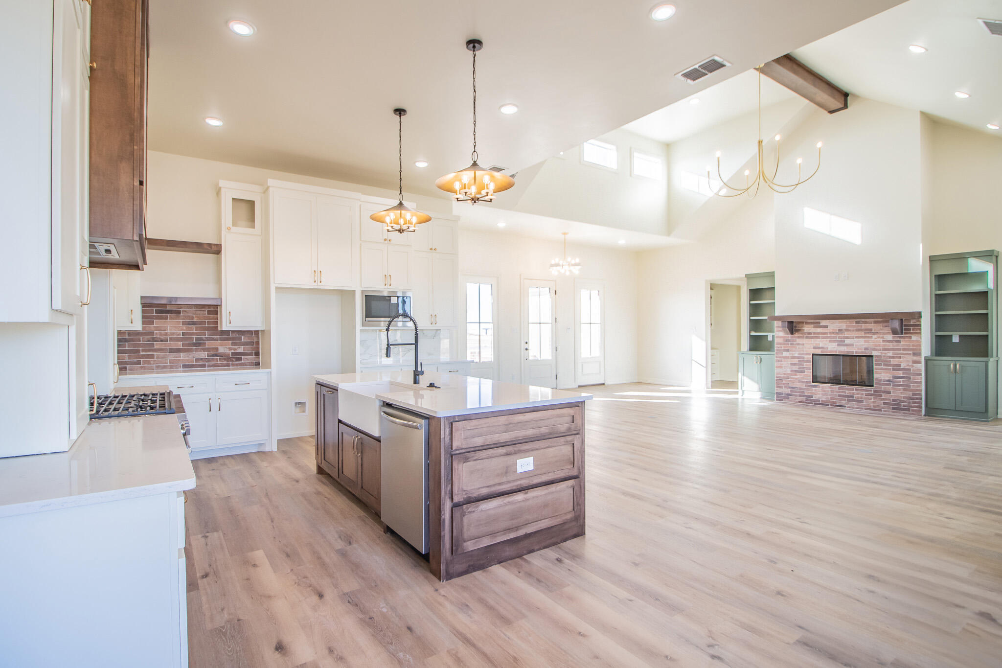303 Juniper New Home, TX 79381 - Photo 10 of 31 a kitchen with stainless steel appliances kitchen island wooden floors cabinets and a counter top space