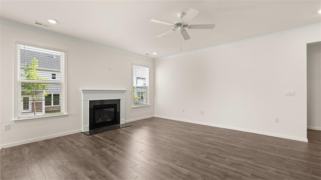 1779 Goodwin Drive Hampton, GA 30228 - Photo 14 of 49 an empty room with wooden floor fireplace and windows