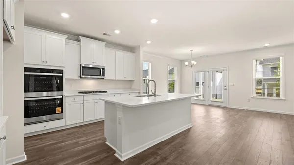 a kitchen with kitchen island granite countertop a sink cabinets and stainless steel appliances
