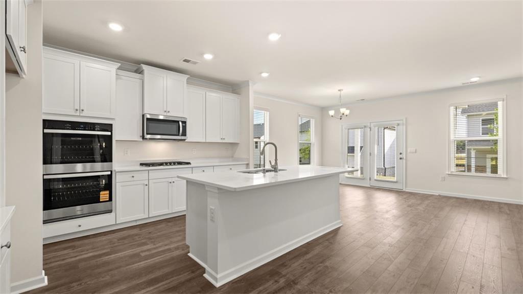 1779 Goodwin Drive Hampton, GA 30228 - Photo 4 of 49 a kitchen with kitchen island granite countertop a sink cabinets and stainless steel appliances