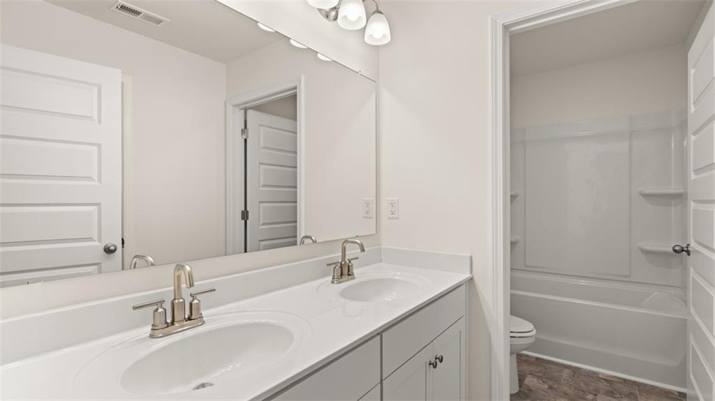 1779 Goodwin Drive Hampton, GA 30228 - Photo 49 of 49 a bathroom with a granite countertop sink a toilet and shower