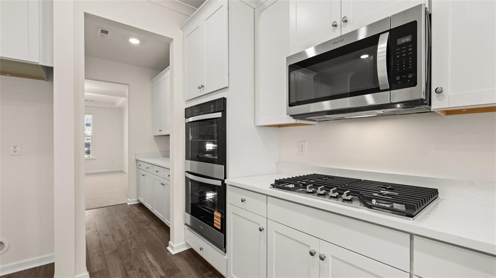 1779 Goodwin Drive Hampton, GA 30228 - Photo 8 of 49 a kitchen with stainless steel appliances a stove a microwave cabinets and wooden floor