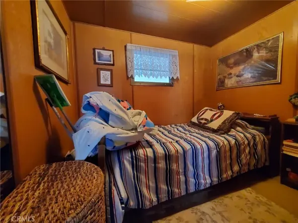 a bedroom with bed and wooden floor