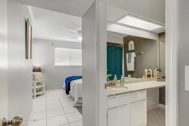 a bedroom with a large bed and a chandelier fan