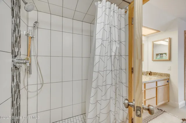 a bedroom with a bed a couch and a chandelier