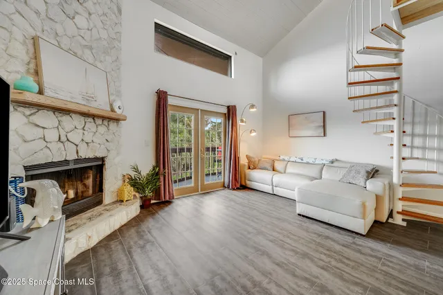 a living room with furniture a flat screen tv and a floor to ceiling window