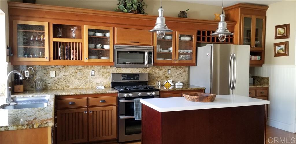 a kitchen with stainless steel appliances granite countertop a stove and a refrigerator
