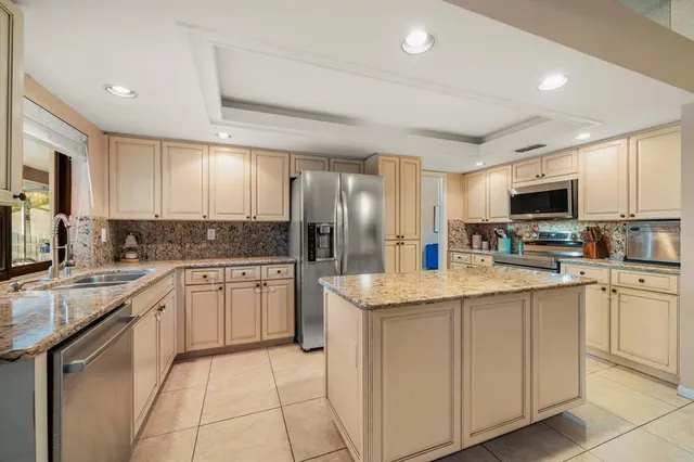 a kitchen with stainless steel appliances granite countertop a refrigerator oven a sink dishwasher and white cabinets with wooden floor