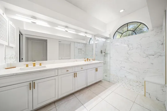 a spacious bathroom with a double vanity sink a mirror and a shower