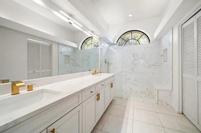 a spacious bathroom with a sink a mirror and shower