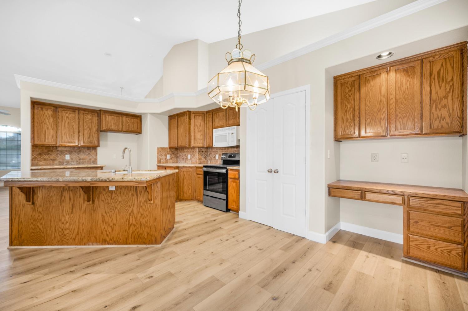 733 Applegate Avenue Clovis, CA 93611 - Photo 11 of 25 a large kitchen with cabinets wooden floor and stainless steel appliances