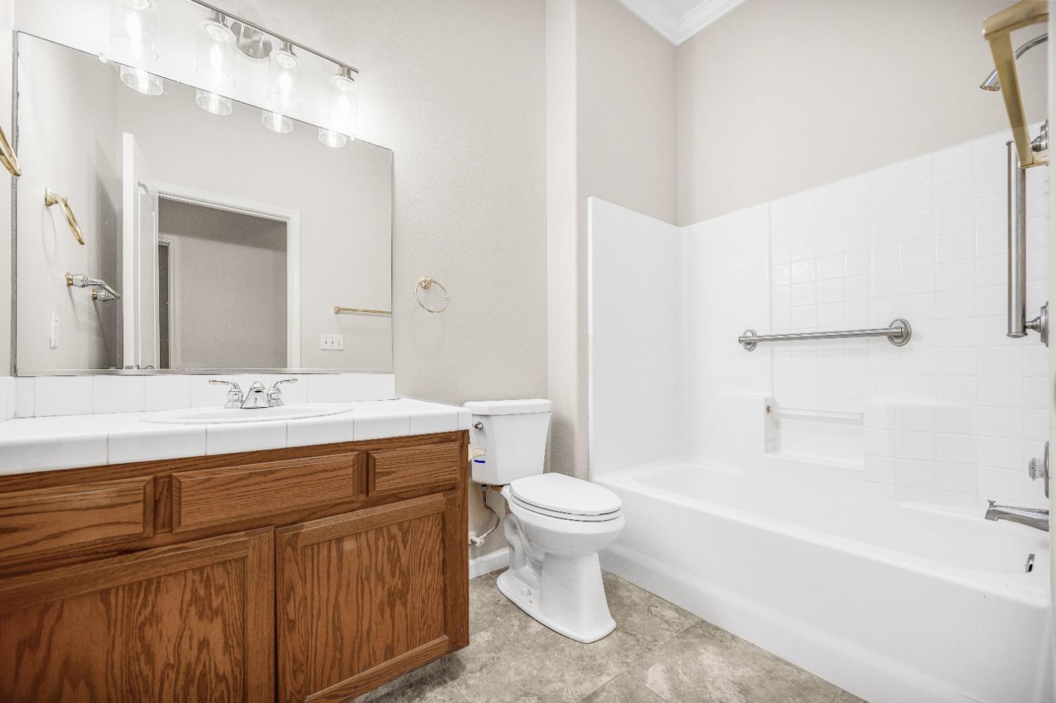 733 Applegate Avenue Clovis, CA 93611 - Photo 12 of 25 a bathroom with a sink a toilet and a bathtub