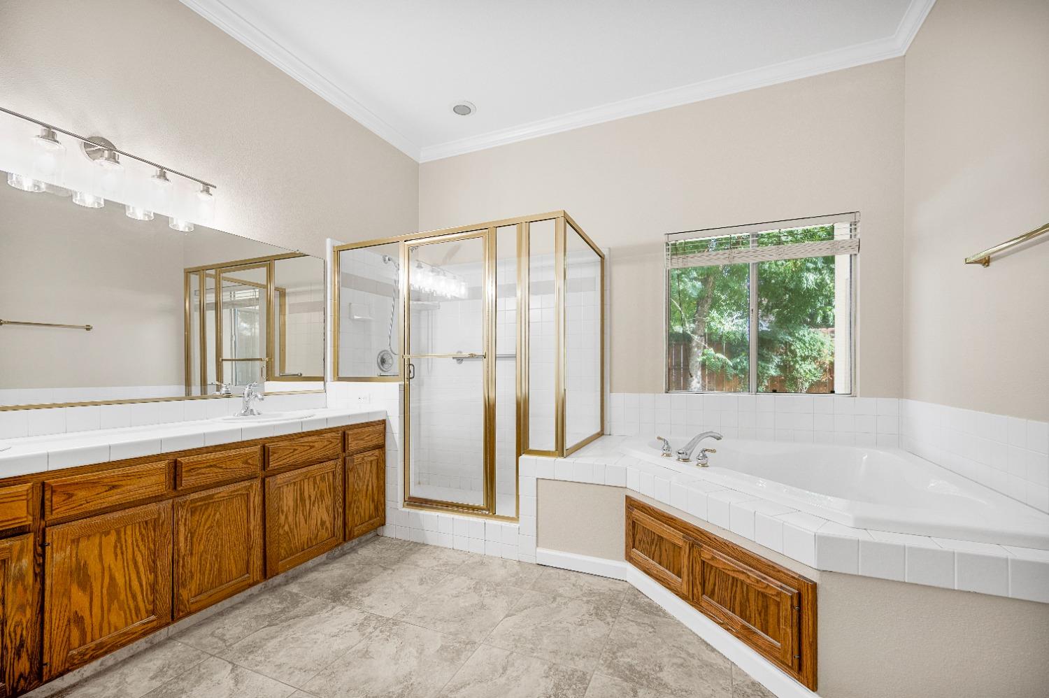 733 Applegate Avenue Clovis, CA 93611 - Photo 21 of 25 a spacious bathroom with a double vanity sink large mirror and a bathtub