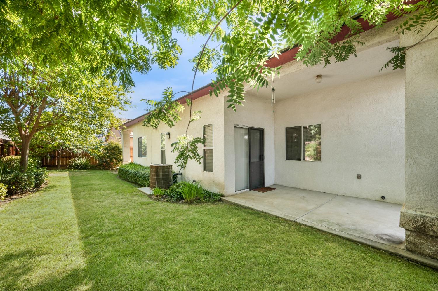 733 Applegate Avenue Clovis, CA 93611 - Photo 25 of 25 a view of a white house with a big yard and a large tree