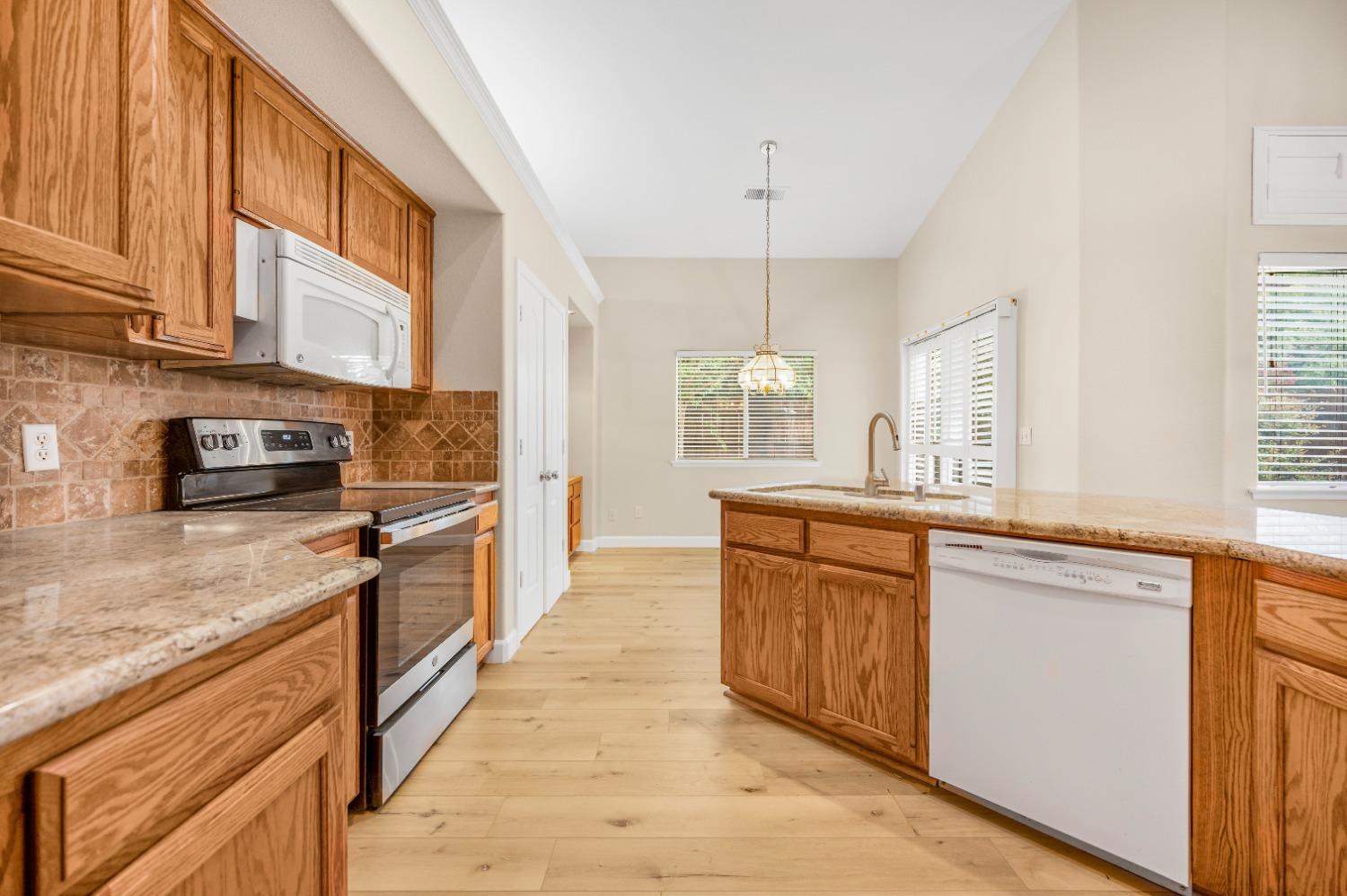 733 Applegate Avenue Clovis, CA 93611 - Photo 7 of 25 a large kitchen with stainless steel appliances granite countertop a stove a sink dishwasher and a refrigerator