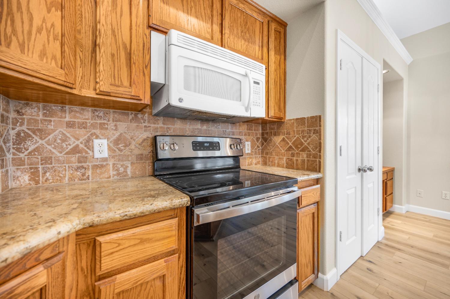 733 Applegate Avenue Clovis, CA 93611 - Photo 8 of 25 a kitchen with stainless steel appliances granite countertop a stove and a microwave