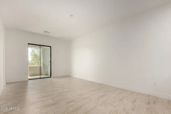 a large white kitchen with kitchen island granite countertop a sink a stove and a refrigerator with wooden floor