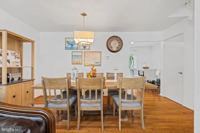 a view of a dining room with furniture a chandelier and wooden floor