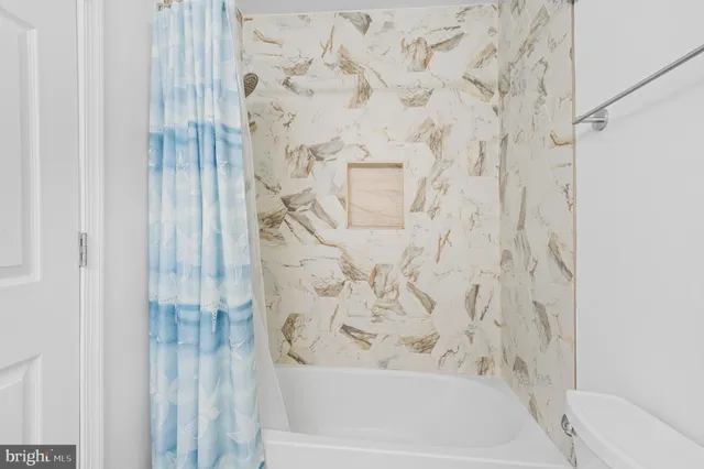 a bedroom with a bed a flat screen tv and dresser