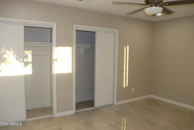 an empty room with windows and closet