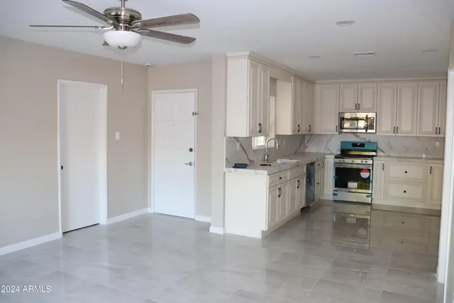 a kitchen with cabinets stainless steel appliances and a window