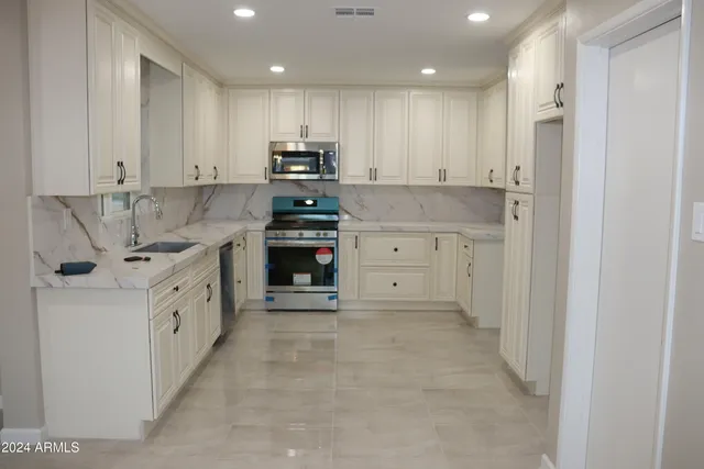 a kitchen with stainless steel appliances granite countertop a sink and cabinets