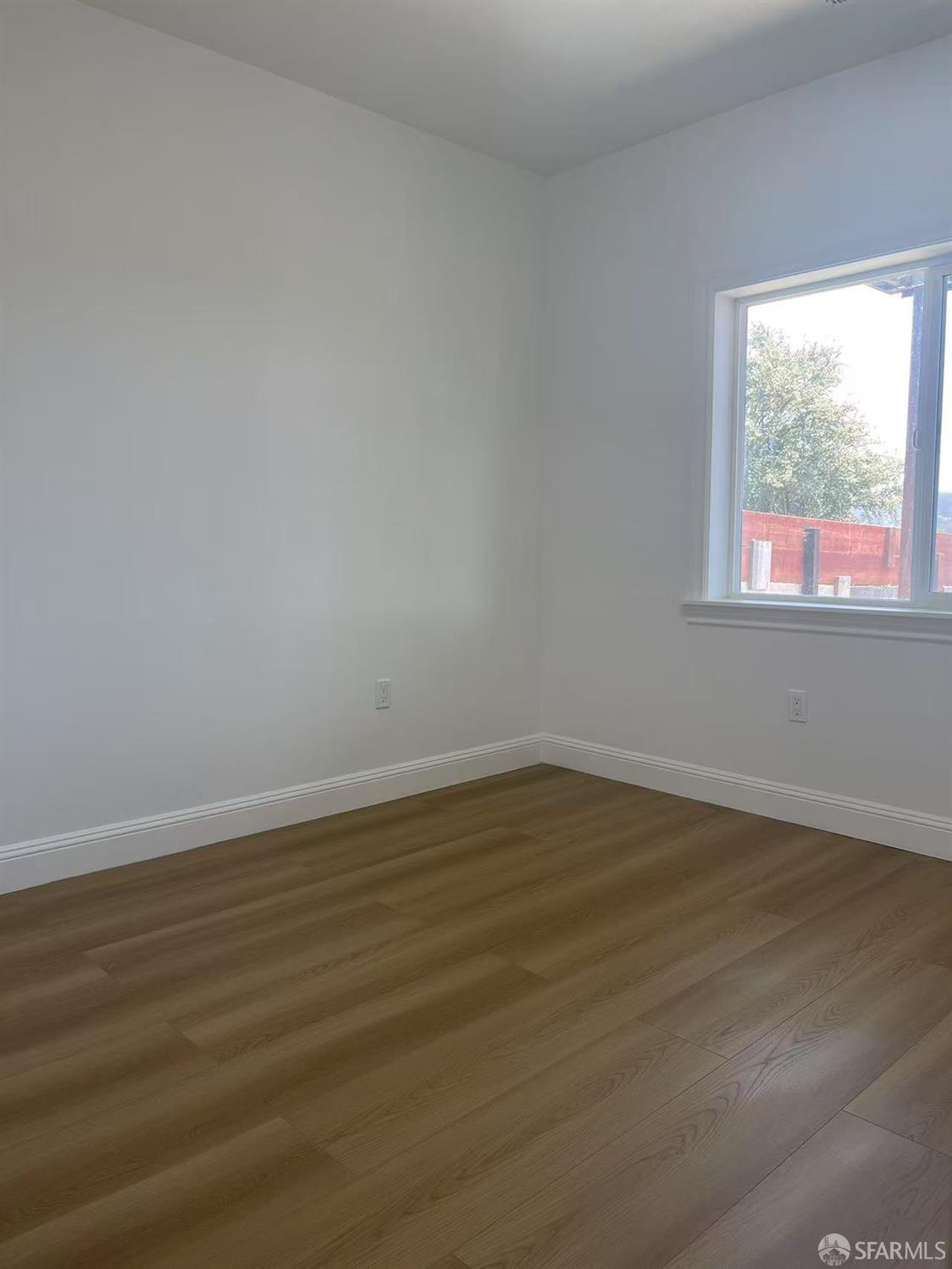 1435 Newcomb Avenue San Francisco, CA 94124 - Photo 4 of 9 a view of an empty room with wooden floor and a window