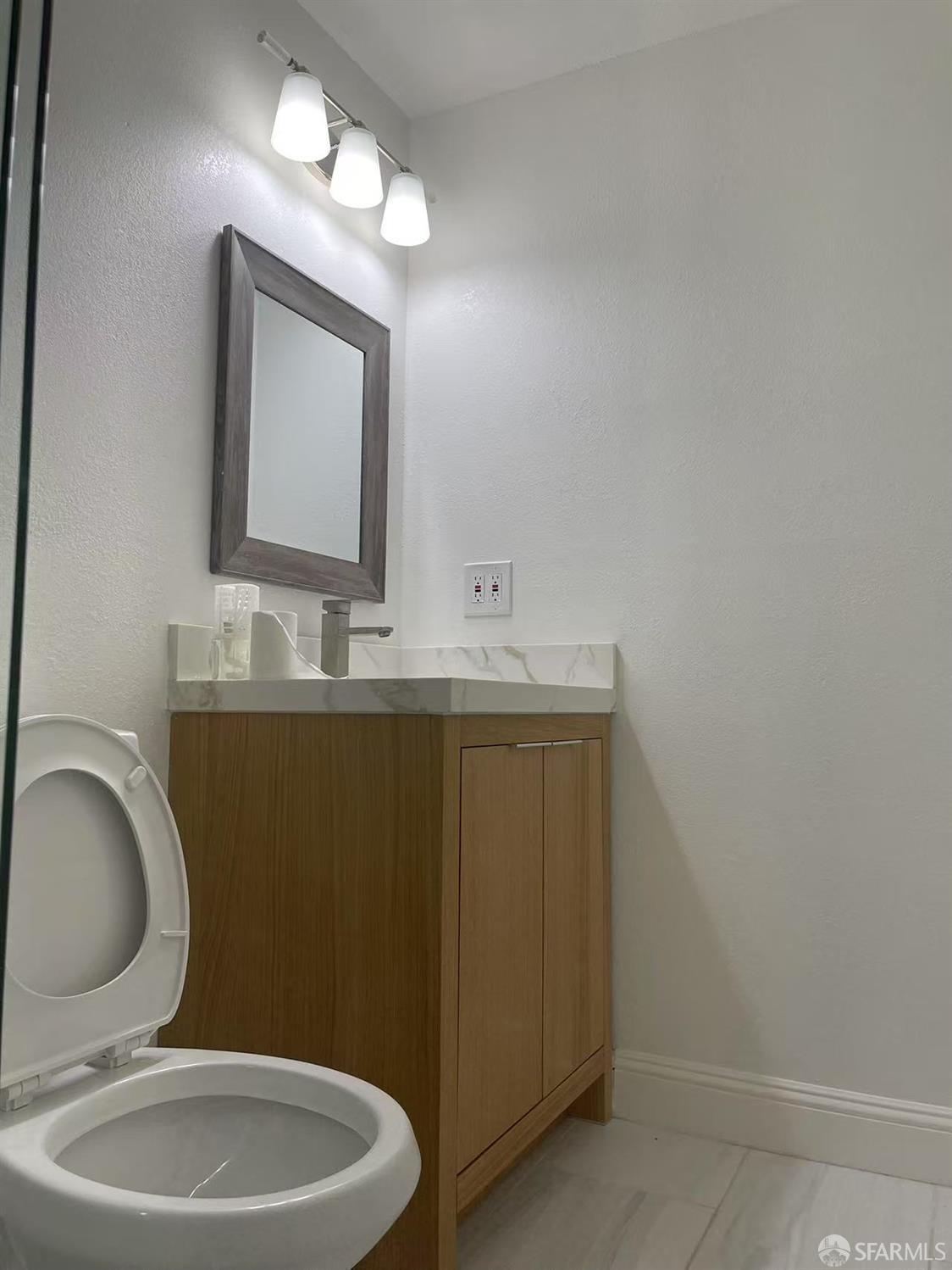 1435 Newcomb Avenue San Francisco, CA 94124 - Photo 9 of 9 a bathroom with a toilet sink vanity granite and mirror