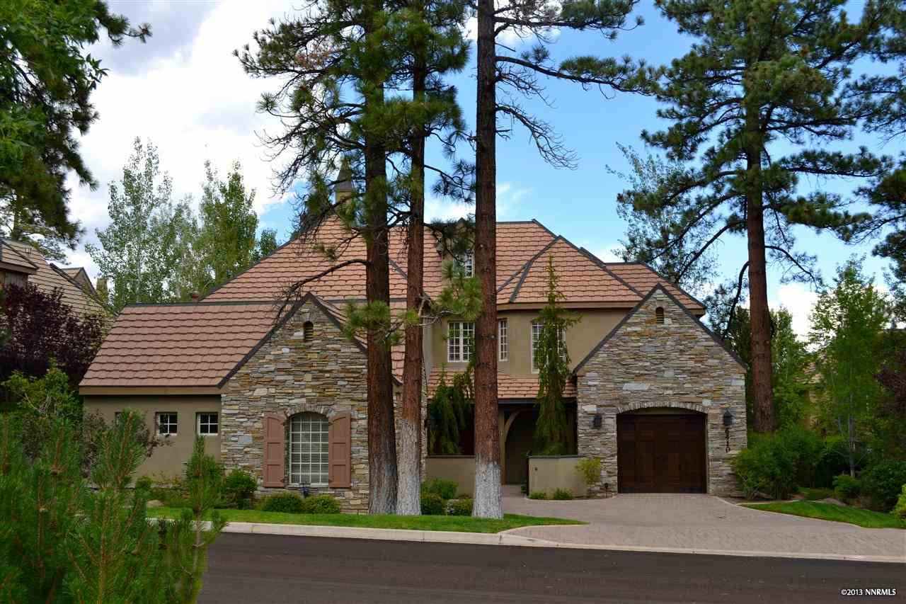 a view of a white house with a tree and plants