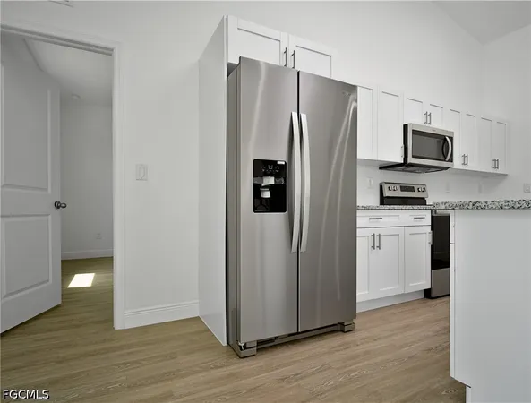 a kitchen with stainless steel appliances granite countertop a refrigerator and a stove top oven