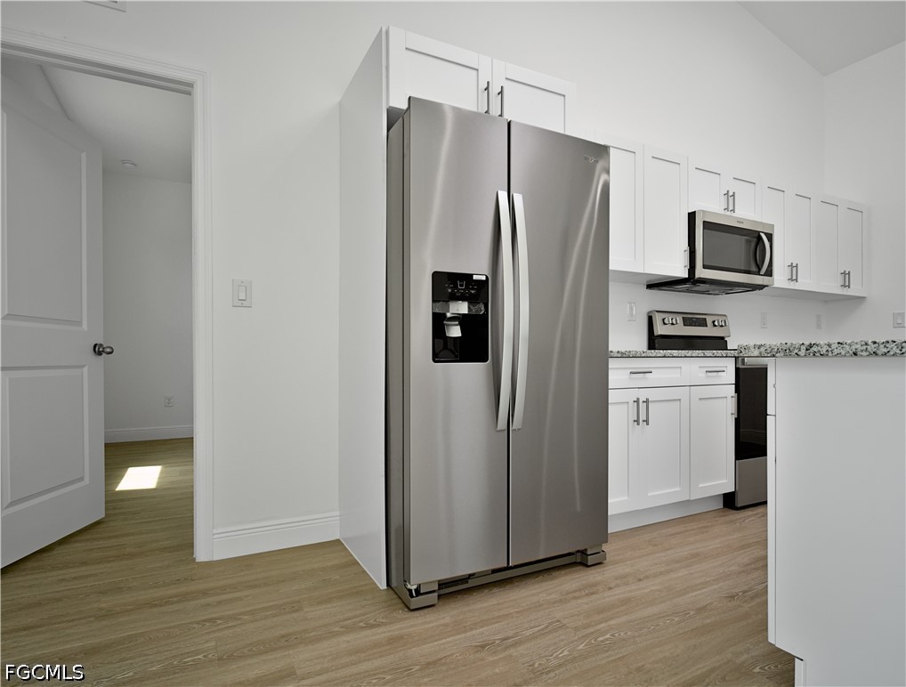 5021 Myrtlewood Road LaBelle, FL 33935 - Photo 3 of 10 a kitchen with stainless steel appliances granite countertop a refrigerator and a stove top oven