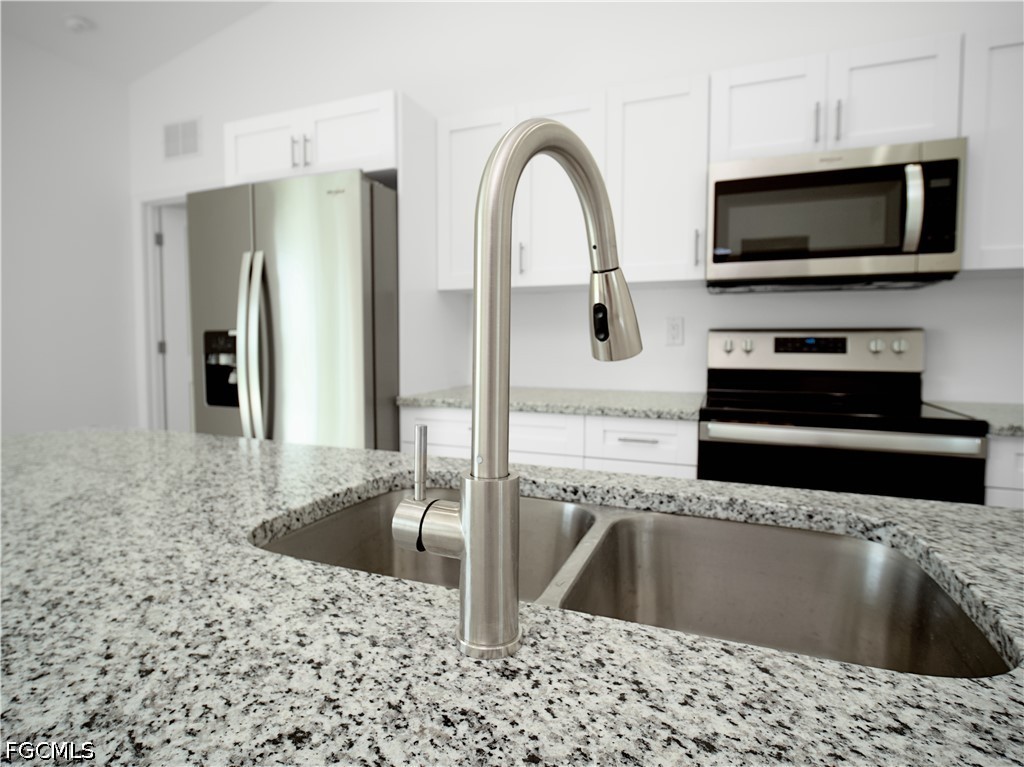 5021 Myrtlewood Road LaBelle, FL 33935 - Photo 4 of 10 a kitchen with stainless steel appliances kitchen island a refrigerator sink and microwave