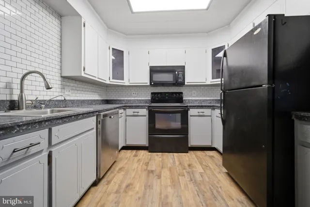 a kitchen with stainless steel appliances granite countertop a refrigerator sink and stove