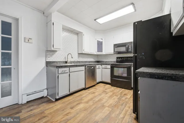 a kitchen with a sink stove top oven and refrigerator